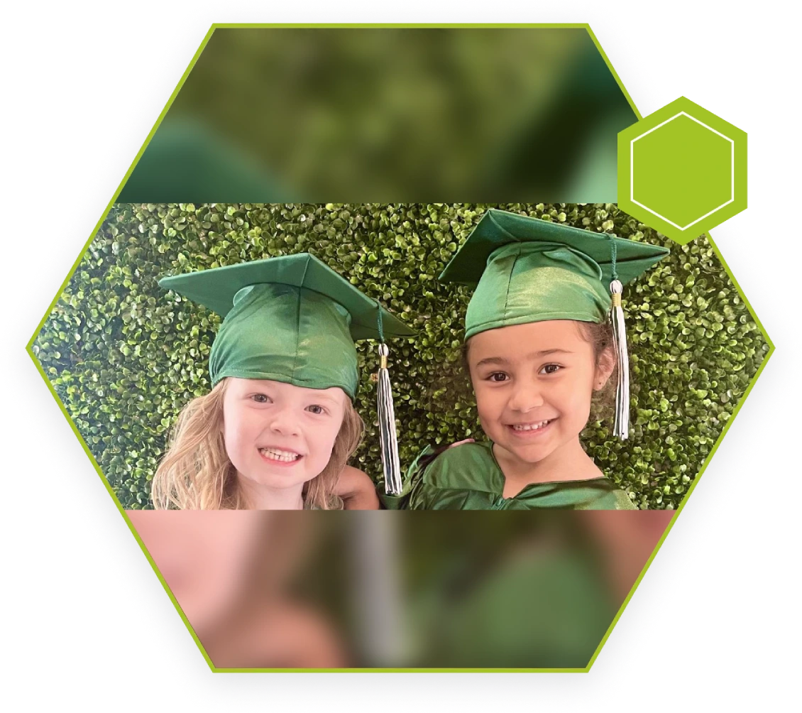 Two children in graduation caps and green gowns.