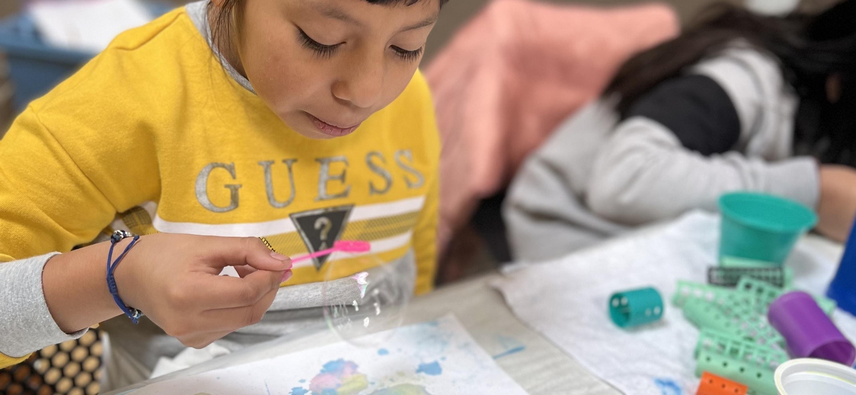 A child is painting with water colors on paper.