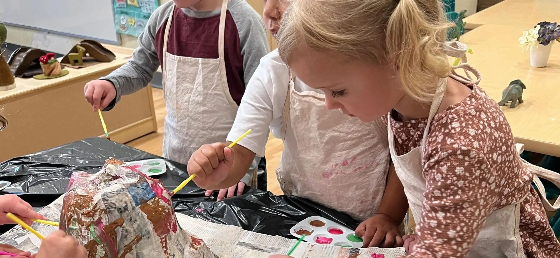 A group of children painting on paper plates.